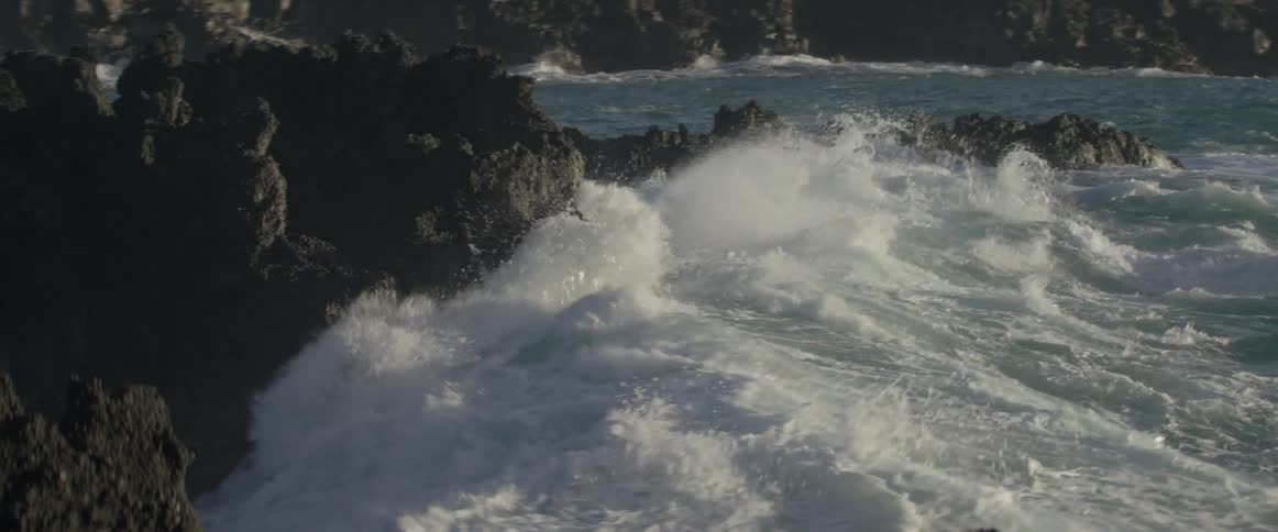 Ocean waves crash into a rocky shore