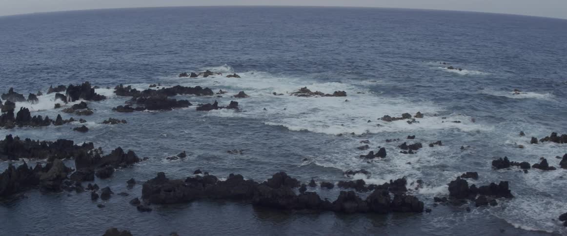 The rough waters are splashing over the rocks