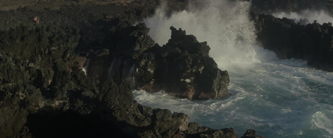 Waves crash against jagged rogs