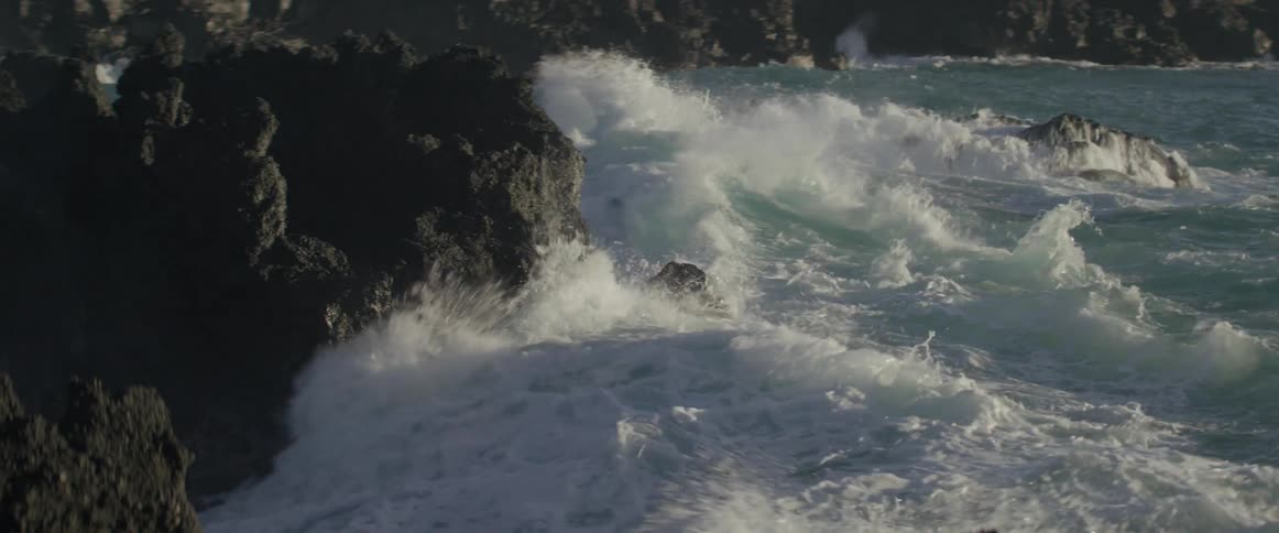 Ocean waves crash into a rocky shore