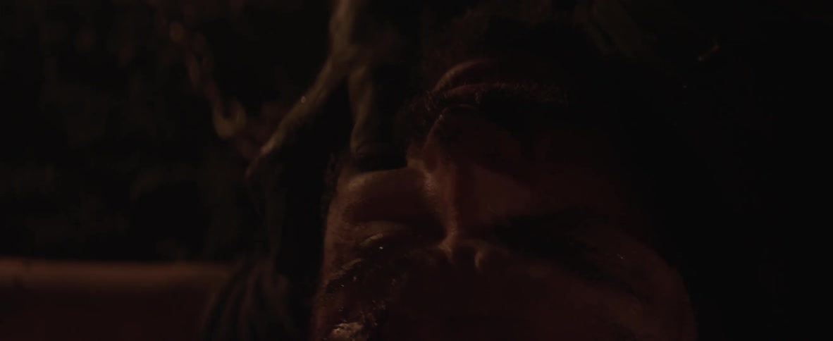 A man grabs on a beaten person's face on the ground