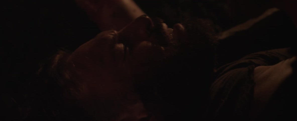 A man grimaces as another shakes him and grabs his face