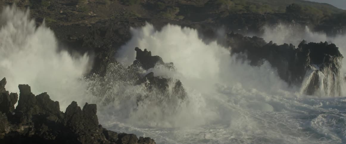 Ocean waves crash into a rocky shore