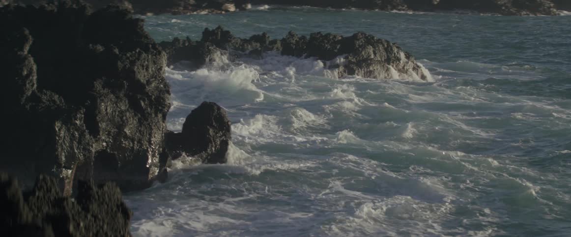 The waves are crashing against the rocks