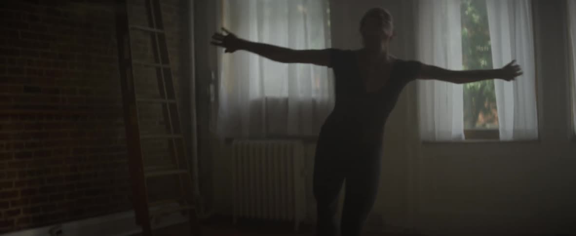 Woman wearing ballet slippers practices ballet