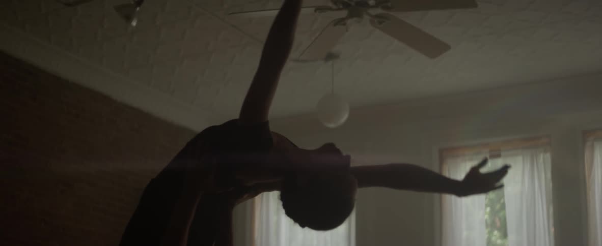 A woman is dancing in a dark room