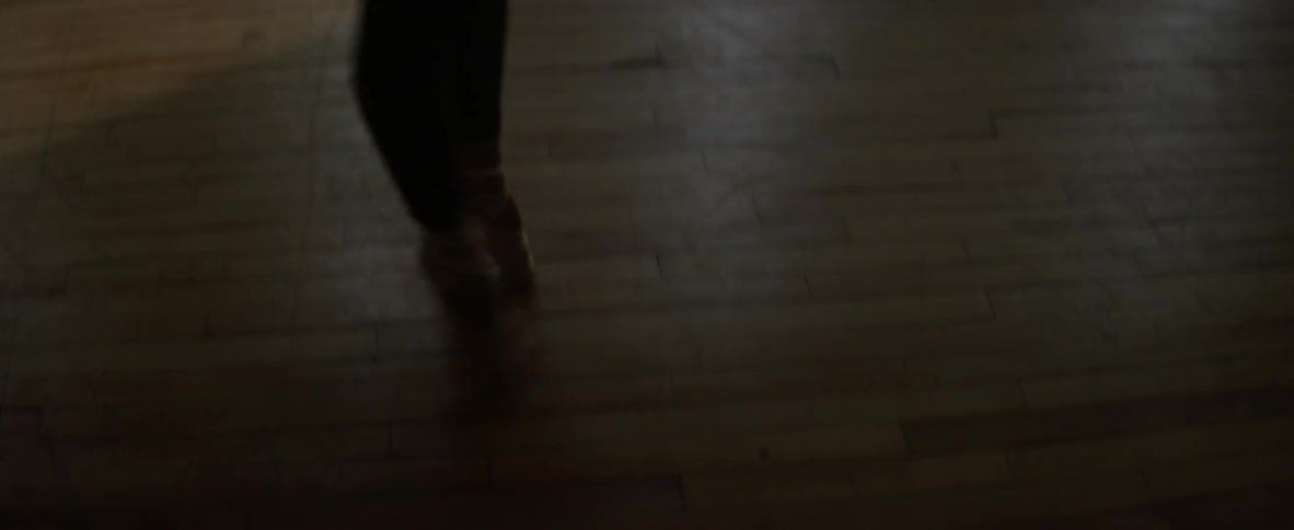A woman twirls and kicks her leg in the air dancing