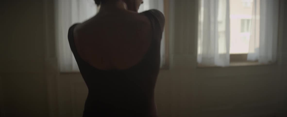Woman practices ballet alone in a studio