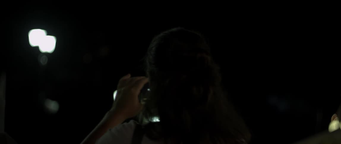 A woman is using a cellphone to film fireworks