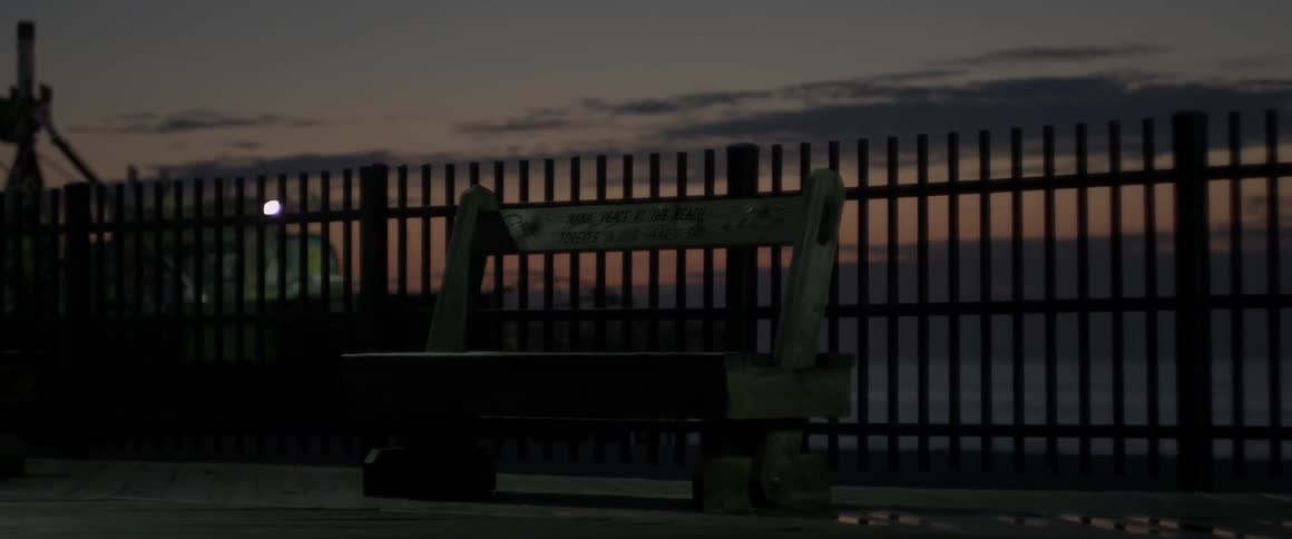 The pier is empty with the benches being barren