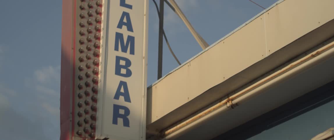 A dentato's clam bar sign on the side of building
