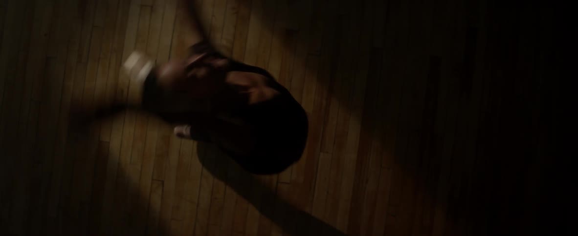 A woman twirls moving across the wood floor