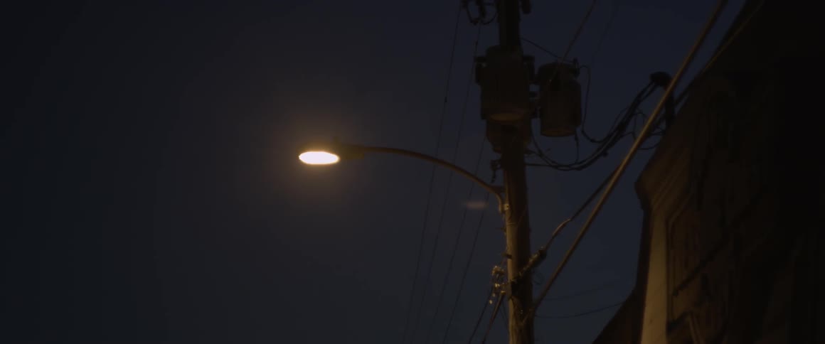 A lamp post is the only source of light on the street