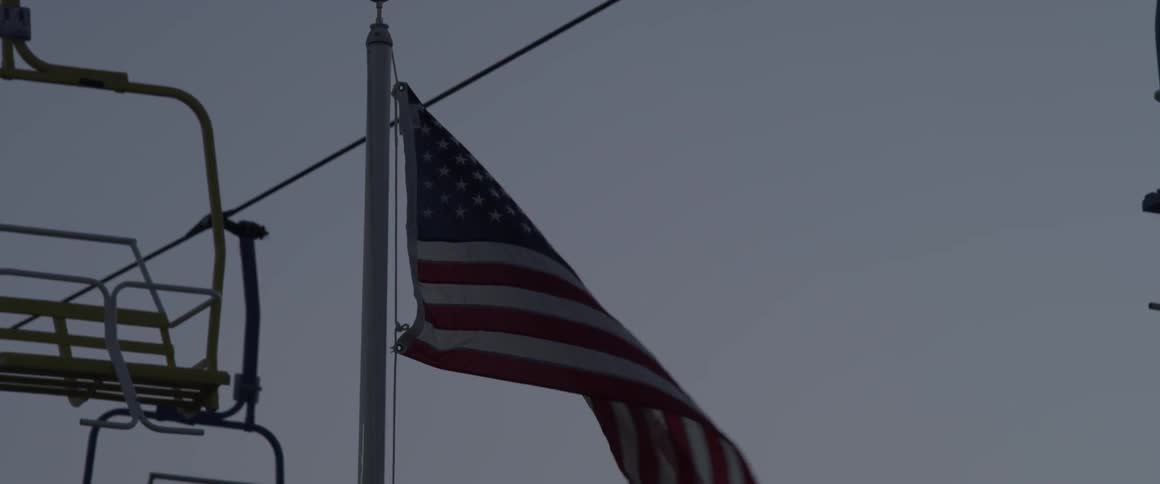 A flag flutters near a ski lift