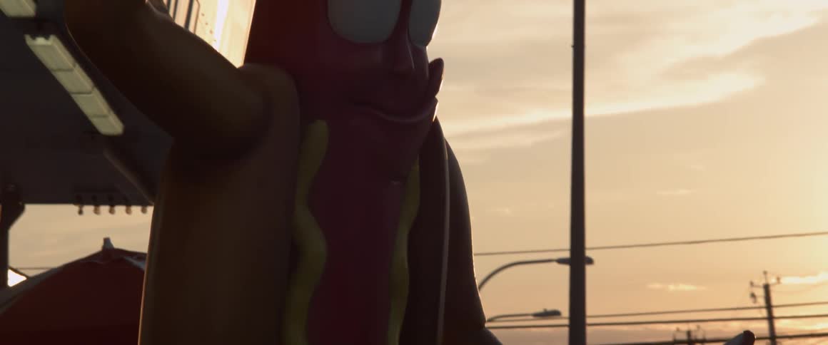 A person walks behind a giant hot dog statue in front of a restaurant