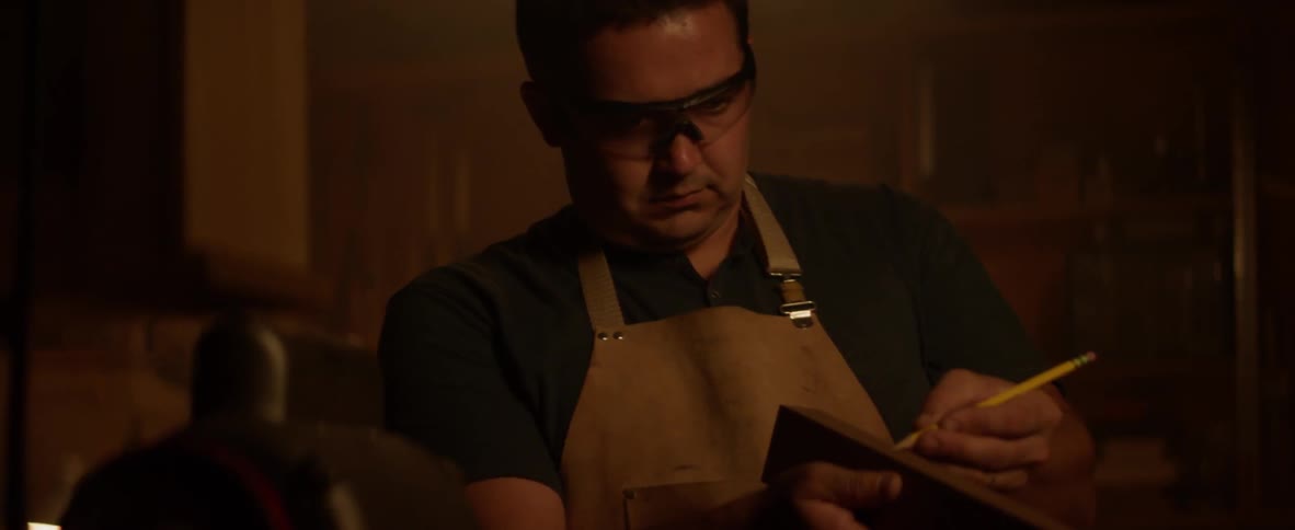 A carpenter draws on a block of wood