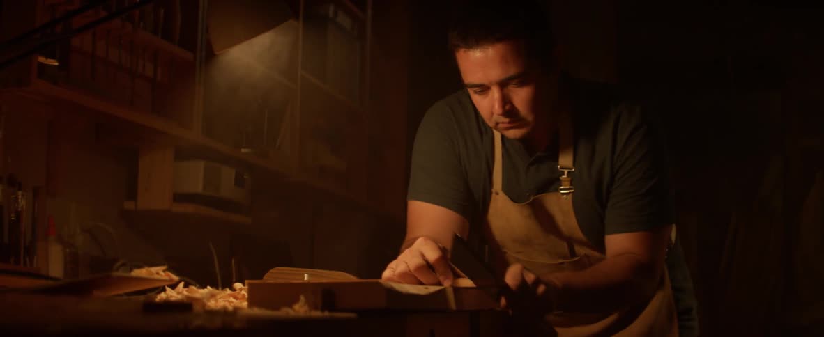 A man is cutting wood in a shop
