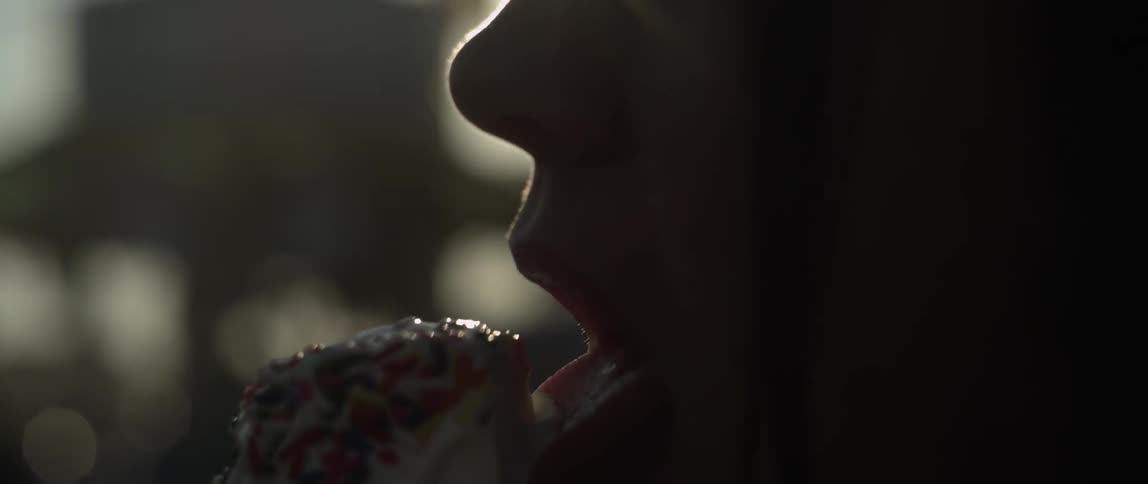 Person licking ice cream as the sun shines against their silhouette
