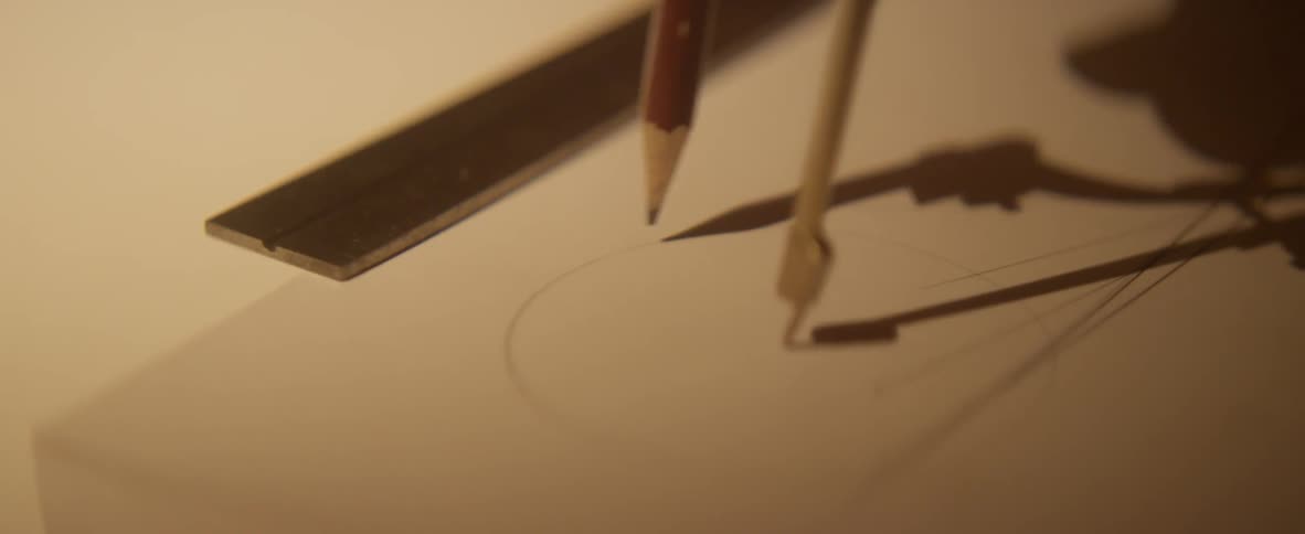 A person uses a compass to draw a circle