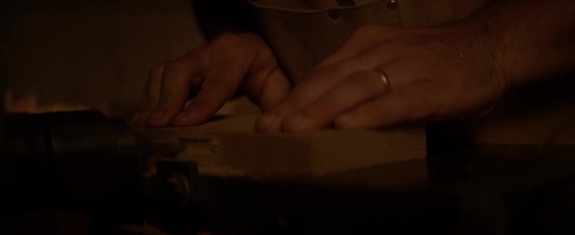 Person getting a massage from another person wearing a wedding band in a dimly lit area