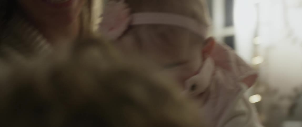A close up shot of a baby laughing and playing with her family