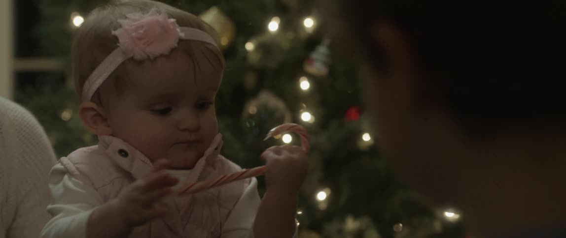 Baby grabbing a putting candy cane in her mouth