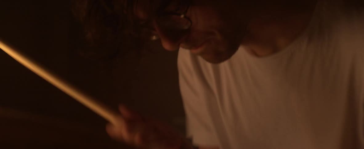 A man plays the drums enthusiastically