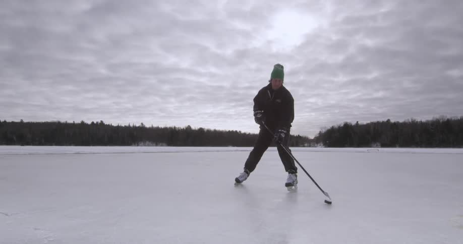 A man is playing ice hockey on an outdoor rink