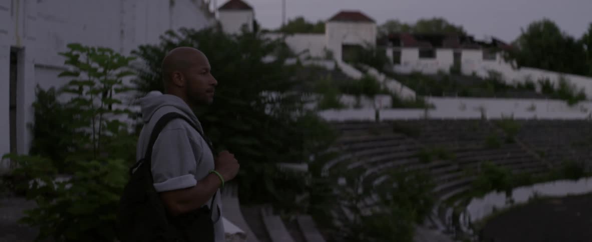 A man stands in an old abandoned stadium