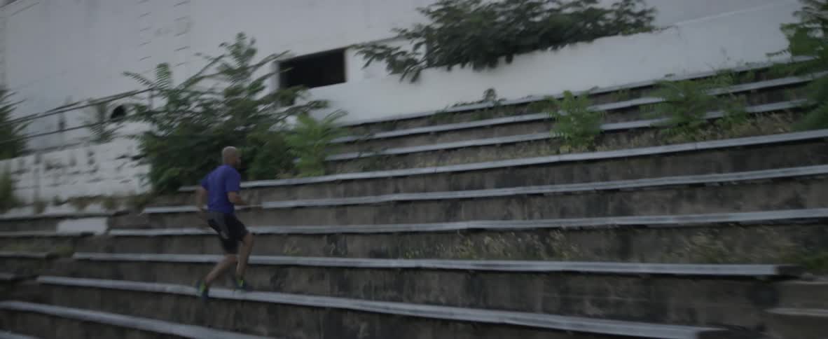 A man sprints up old stadium bleachers