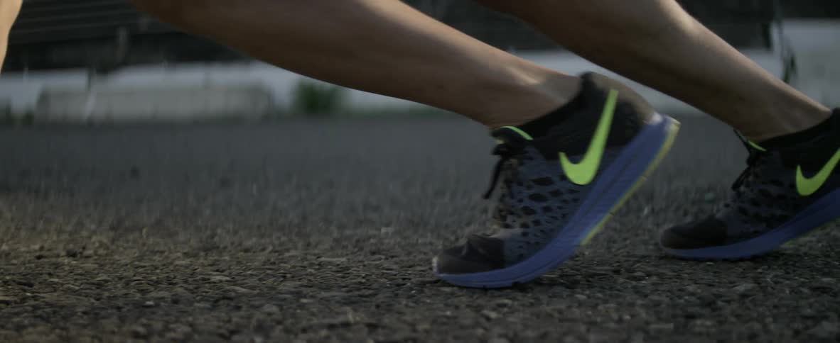 A person in running shoes stretches on a track