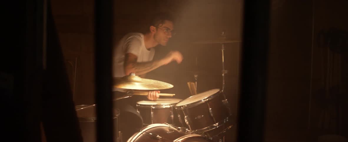 Man looks at cymbals on drum set