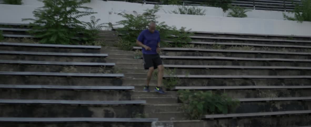 Man runs down steps by bleacher seats in a stadium