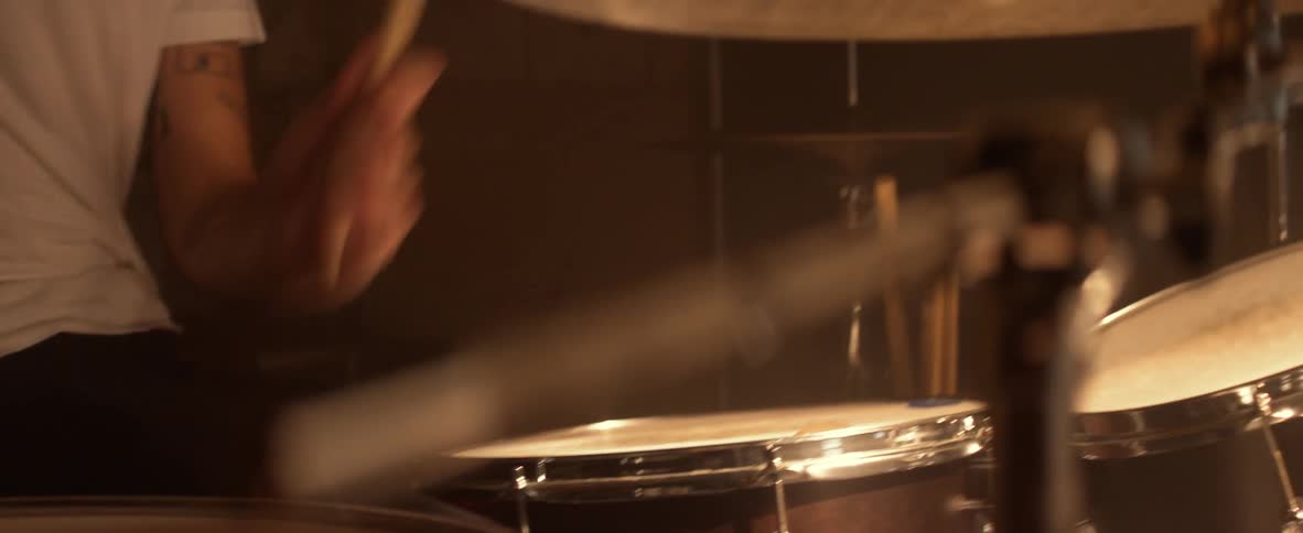 A man in white plays the drums