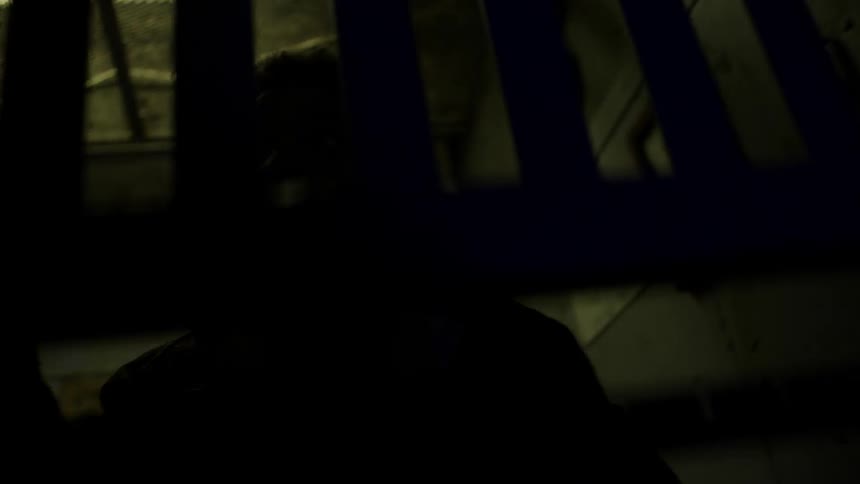 A man gets in an elevator and closes the gate