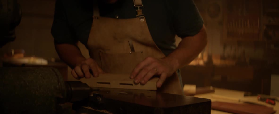 Man sanding piece of wood on machine in workshop