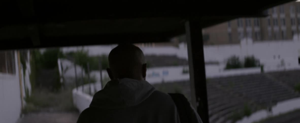 A man walks in an abandoned stadium