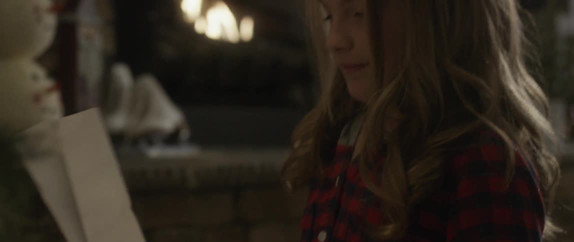 Girls spinning a plain box around and around sitting in front of a fireplace