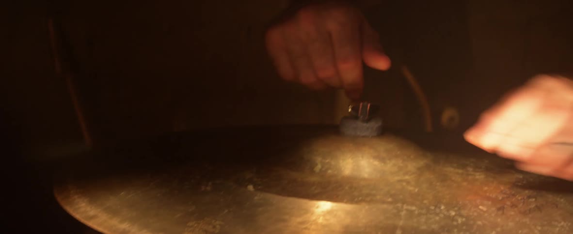A man places a cymbal on his drum set