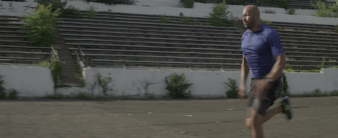 A man runs in an abandoned stadium
