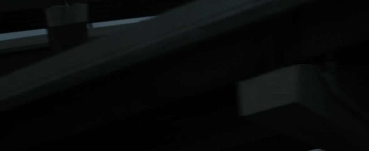 A vehicle drives beneath an overpass at night
