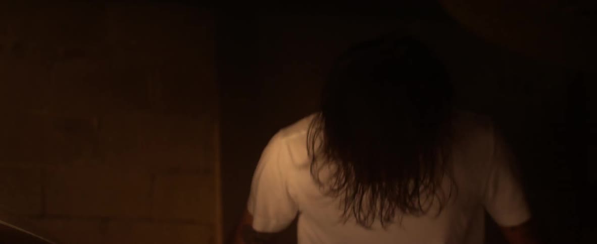 Man playing drums in a dimly lit area