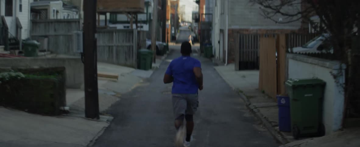 A man jogs in a city alley