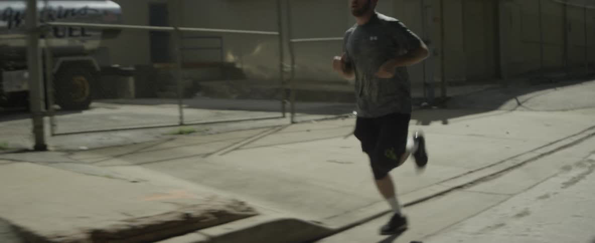 A man is running along the side of a street