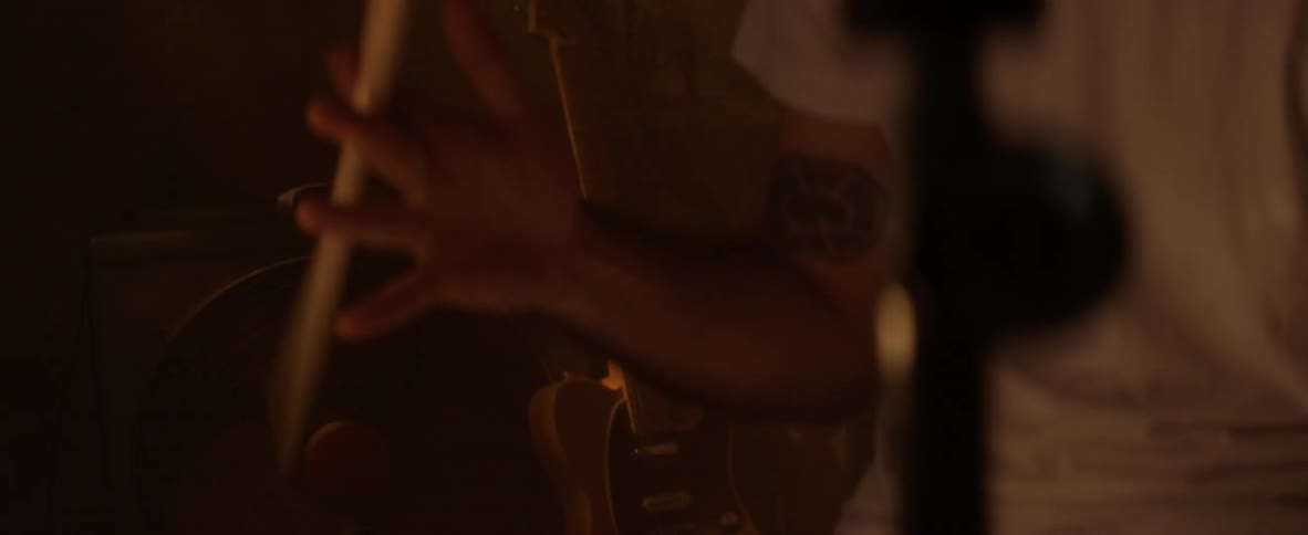 A drummer spins a drumstick in his hand before playing the drums