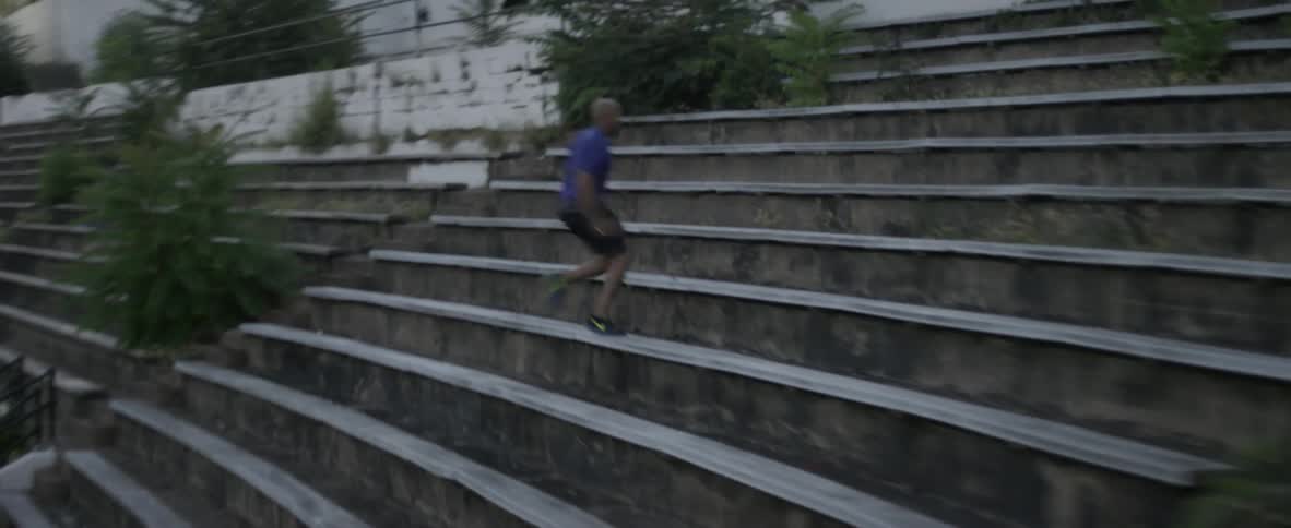 A man runs fast up the bleachers