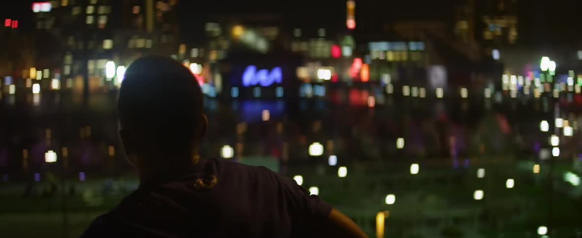 A man looks out over the city at night