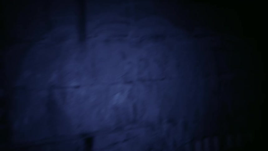 Flashlight shines on a wall at night