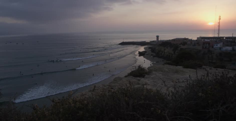 Waves roll onto a beach at sunrise