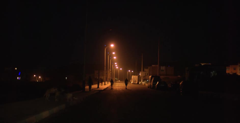 People are skateboarding down the street at night
